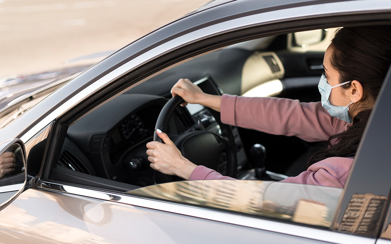 Private-hire driver wearing a mask while operating a vehicle.
